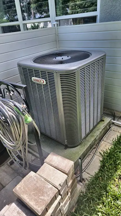 Lennox condenser unit installed on a backyard patio corner, Jacksonville FL