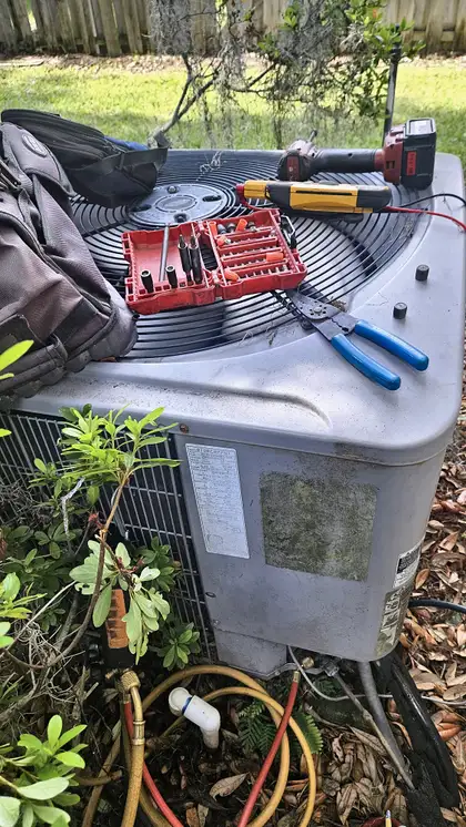 Technician tools and multimeter on top of an older condenser during an AC repair visit, Jacksonville FL