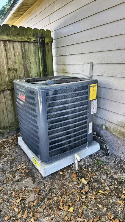 Goodman condenser unit installed on a concrete pad beside a home, Jacksonville FL