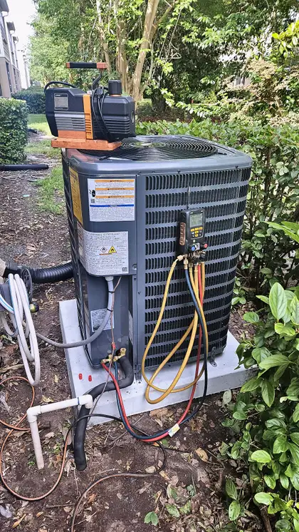 Vacuum pump and gauge manifold connected to a condenser during refrigerant service, Jacksonville FL